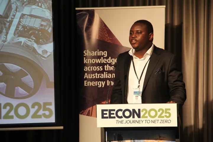 Kenneth speaking at a lectern marked EECON 2025