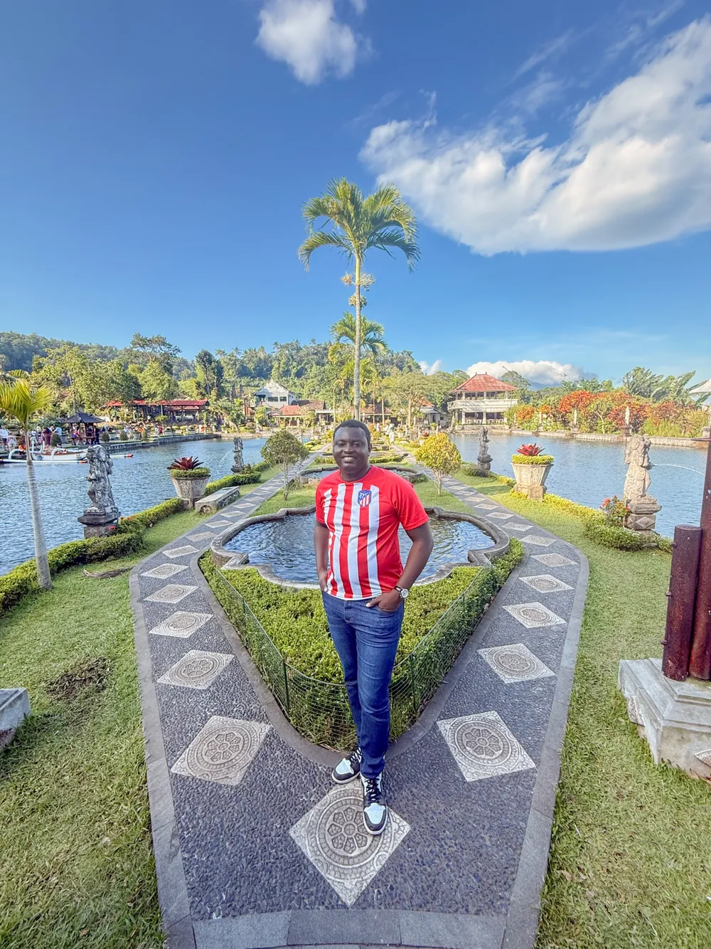 Kenneth standing on a garden path between fountains and palm trees