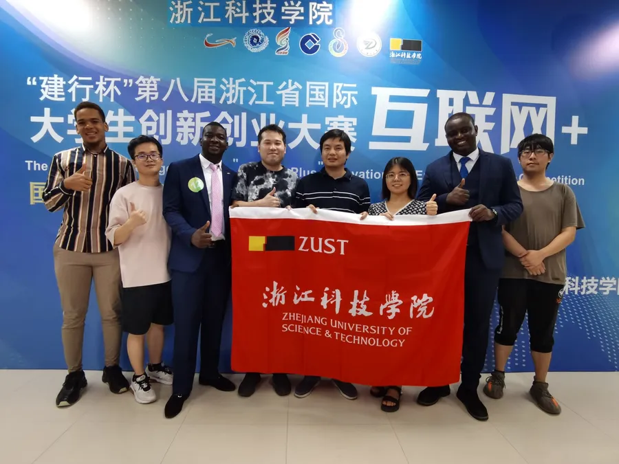 Kenneth with the ZUST team holding the university banner at the Zhejiang Internet Plus competition