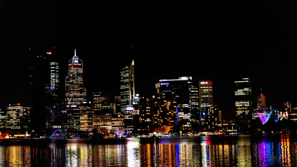 Perth skyline at night with lights reflected in the river
