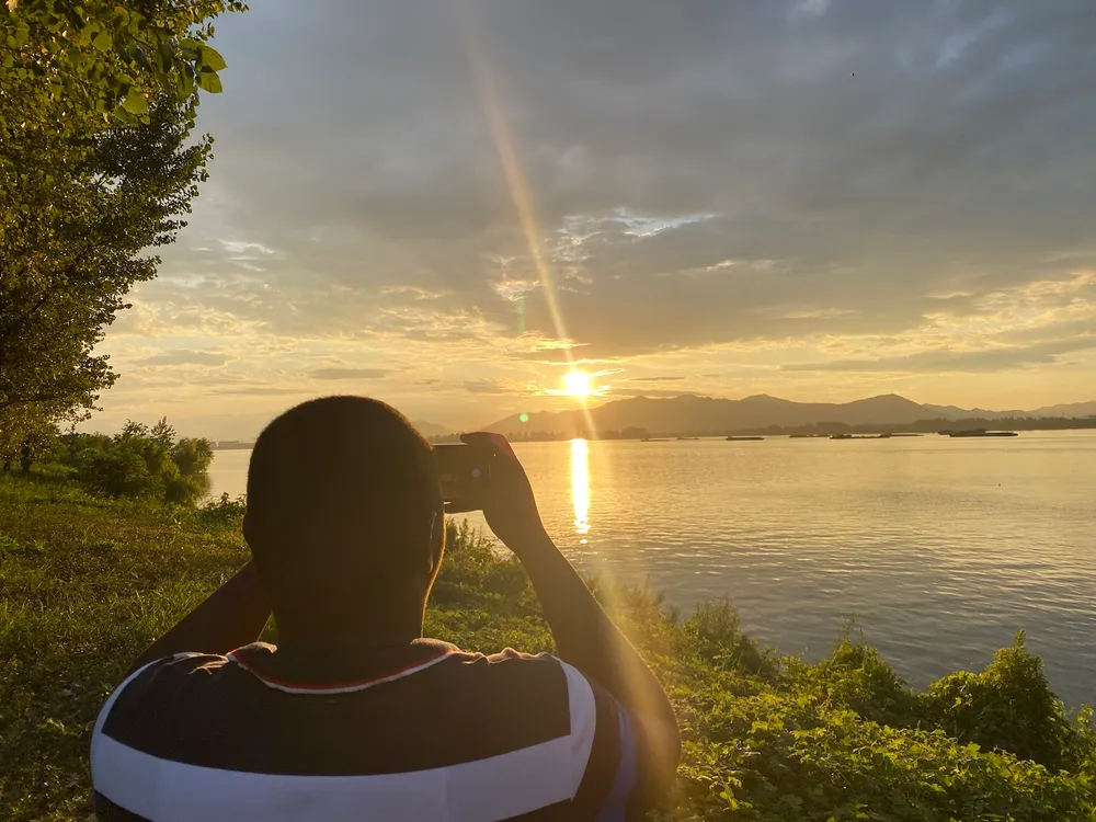 Kenneth photographing the sun setting over a lake