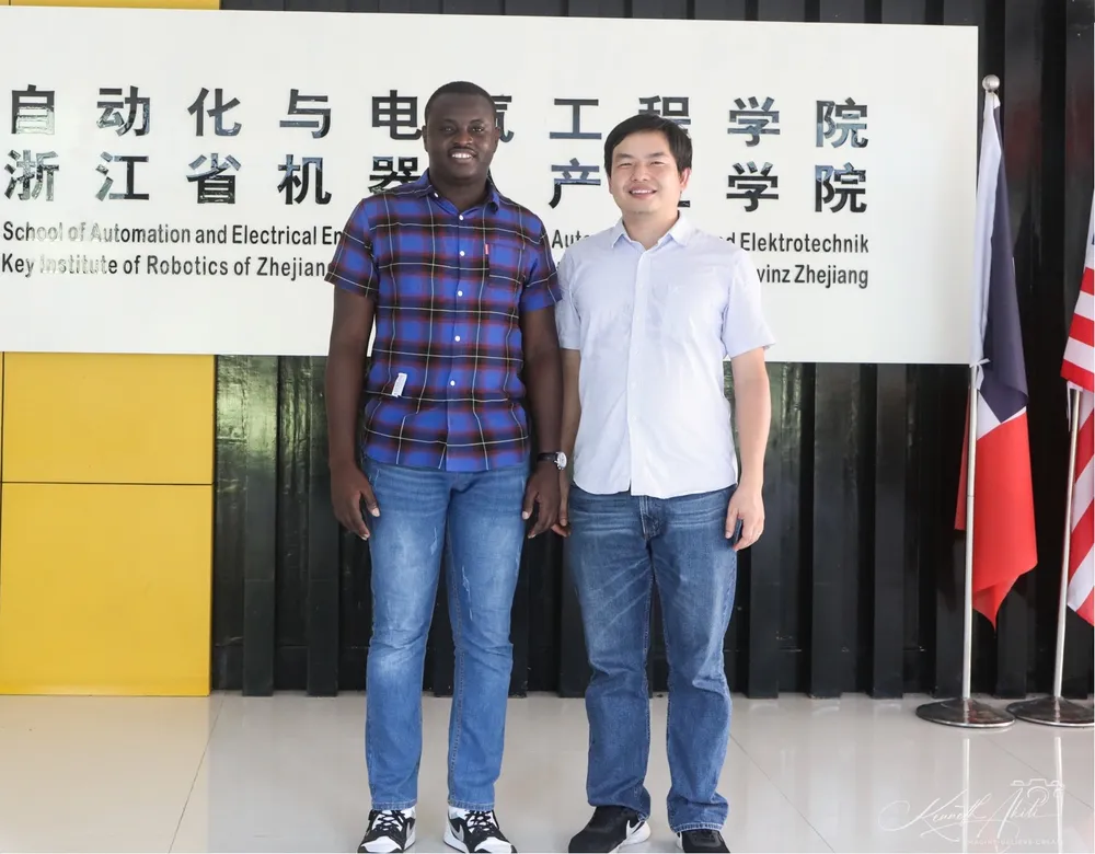 Kenneth standing with a teacher